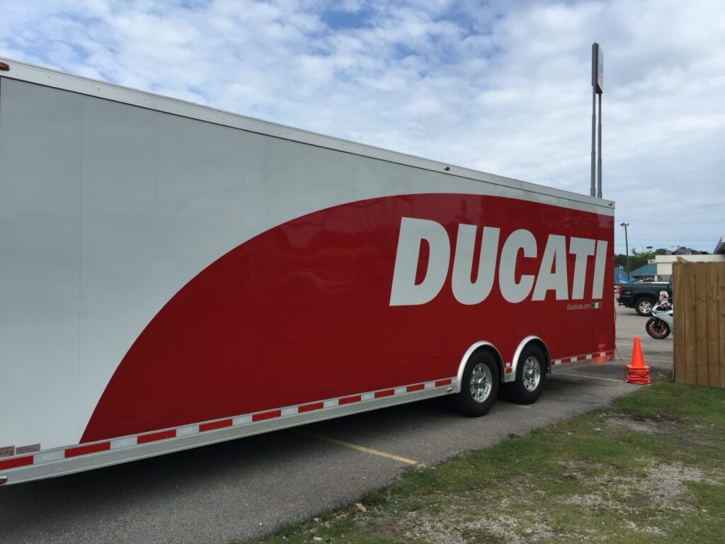 Ducati red-and-white enclosed cargo trailer wrap side view at Big #1 Motorsports in Homewood, Alabama