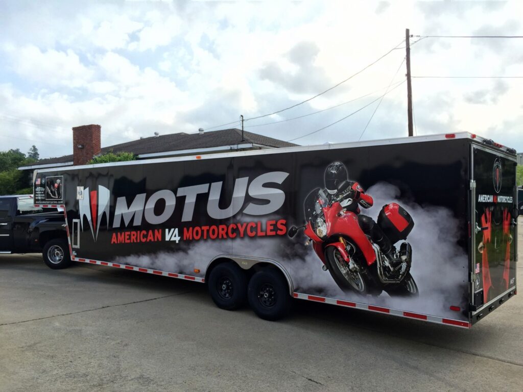 Gooseneck nose of the Motus trailer with motorcycle graphics, website and American flag