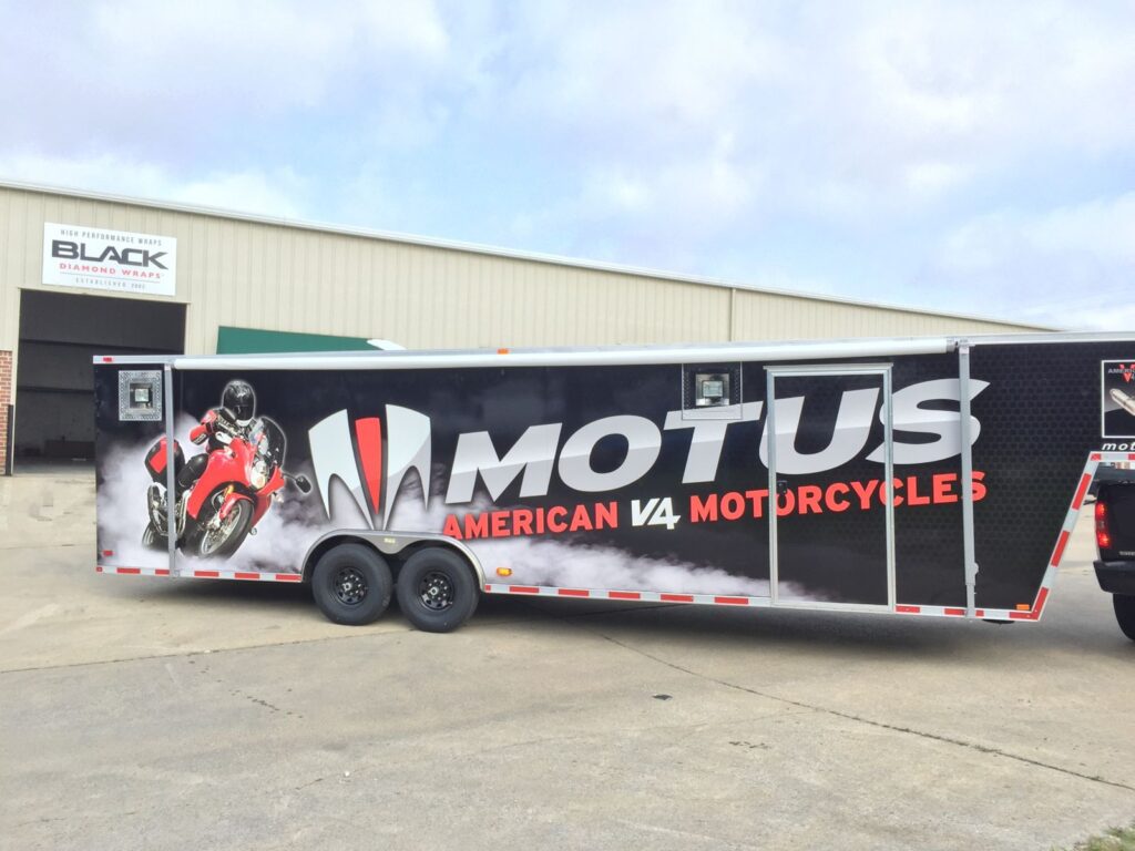 Passenger side of the Motus trailer with red motorcycle and smoke graphics