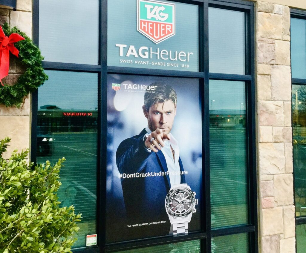 TAG Heuer window graphics on a retail storefront near Wichita Falls, Texas: logo panel above a #DontCrackUnderPressure campaign graphic with a Carrera watch.
