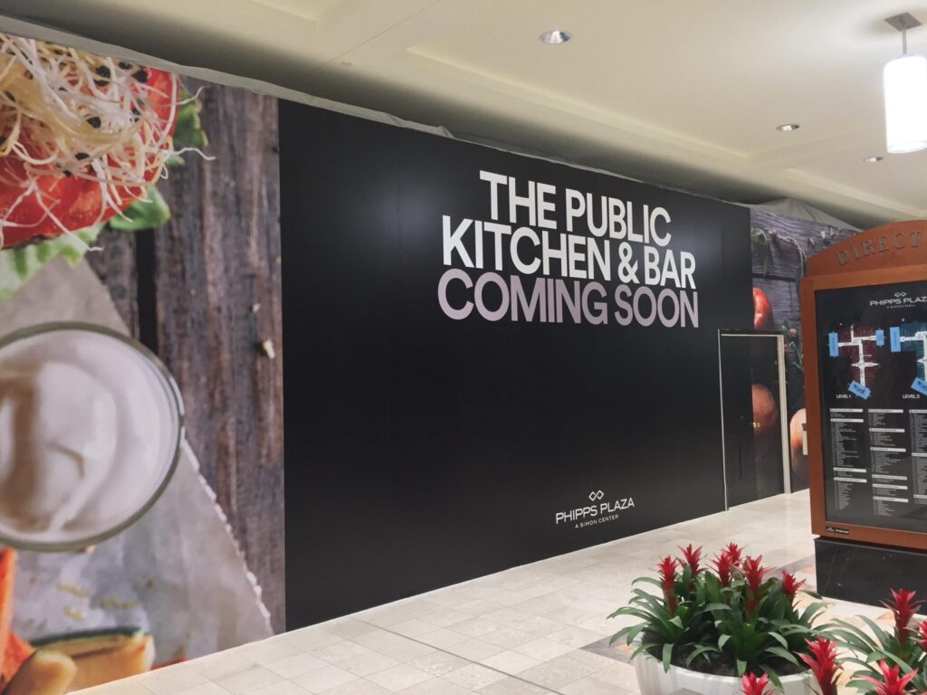Large-format coming-soon lettering for The Public Kitchen & Bar on a Phipps Plaza retail barricade in Buckhead Atlanta.