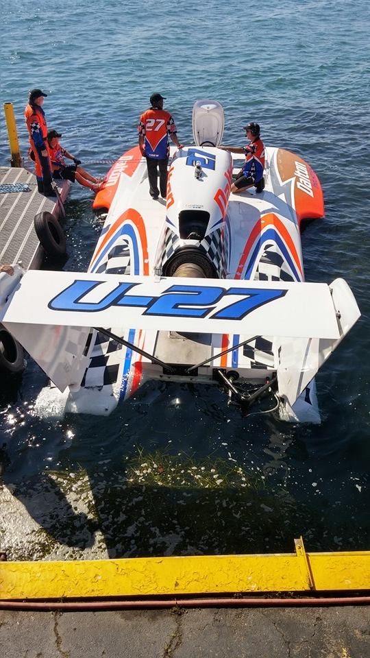 Rear view of the wrapped U-27 hydroplane at the dock, showing the U-27 rear wing graphic and sponson graphics.