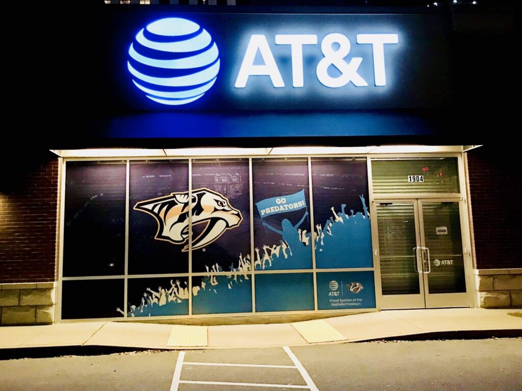 Nashville window graphics on an AT&T storefront with Predators logo, GO PREDATORS fan silhouettes, and illuminated AT&T sign.