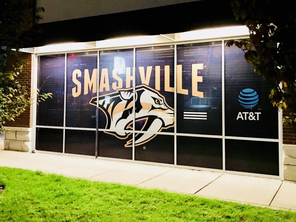 Nashville window graphics angled night view with SMASHVILLE text, Predators logo, and AT&T branding on storefront glass.