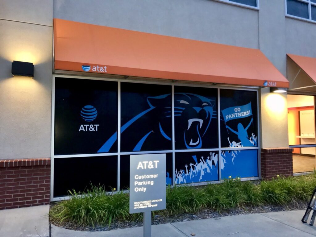 Finished AT&T window graphics with Panthers artwork beneath an orange awning