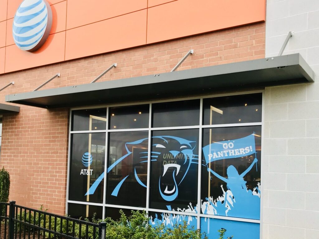 Close view of AT&T storefront window perf with the Panthers logo and Go Panthers artwork