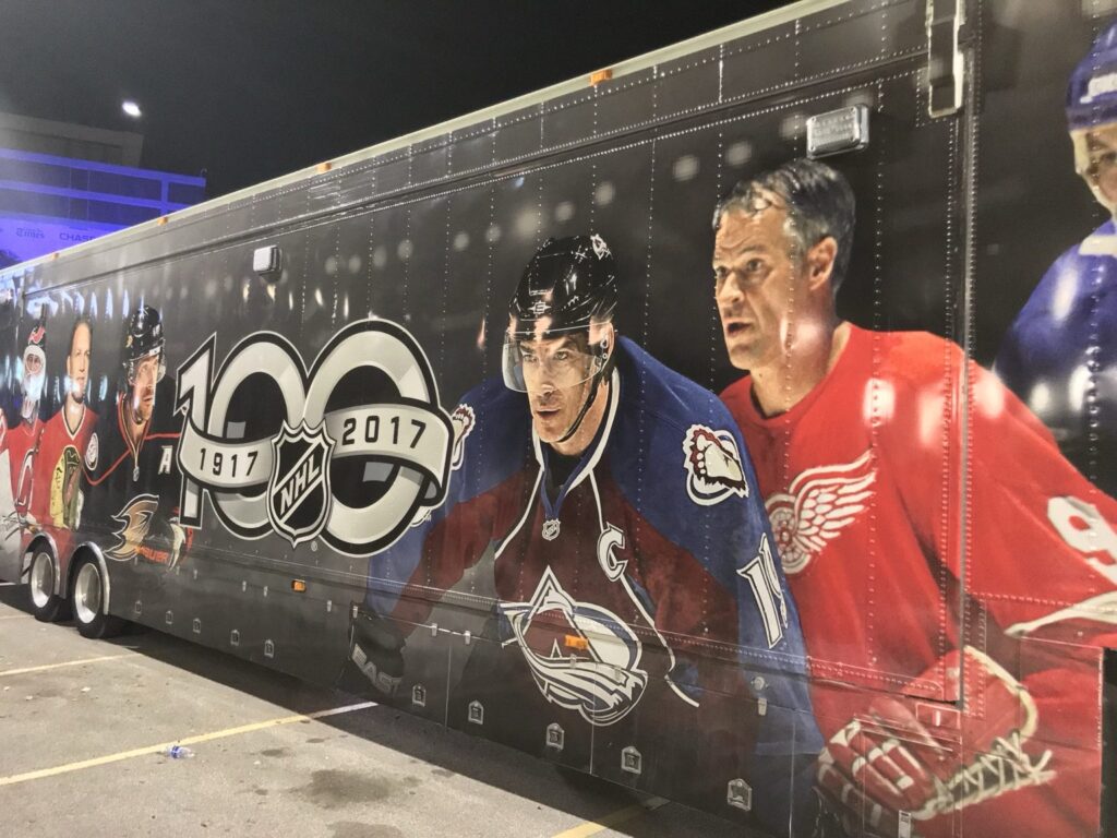 Long black NHL 100th-anniversary trailer wrap with historic NHL hockey players surrounding the 1917–2017 Centennial emblem