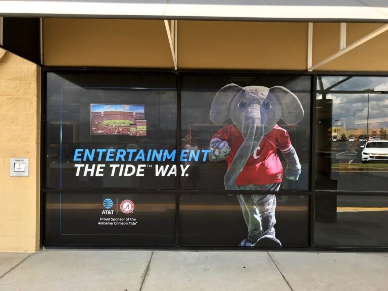 Crimson Tide window graphics Birmingham: wide front view of AT&T storefront window graphics in Birmingham featuring the Alabama Crimson Tide elephant mascot, stadium imagery, and Entertainment the Tide Way messaging.