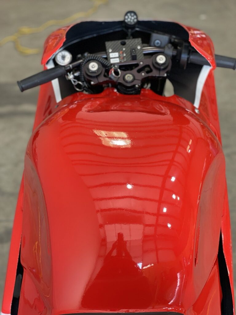 Close-up of a red aerodynamic racing motorcycle fairing in the shop