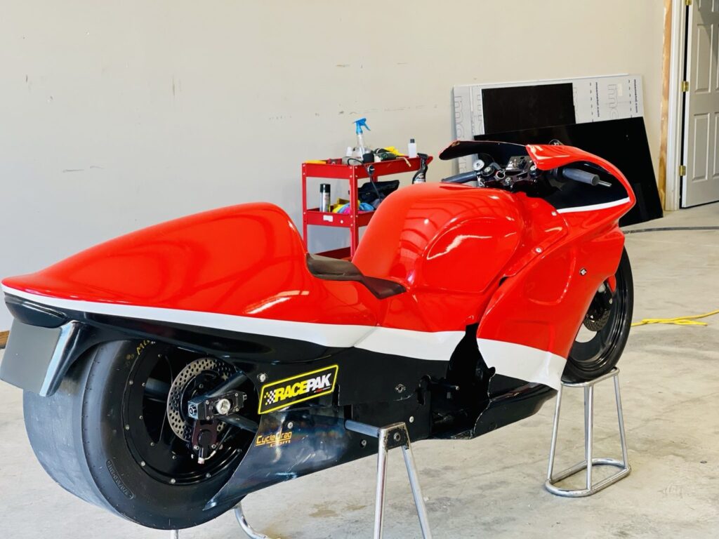 Motorcycle graphics flowing across an aerodynamic fairing, viewed from the rear side