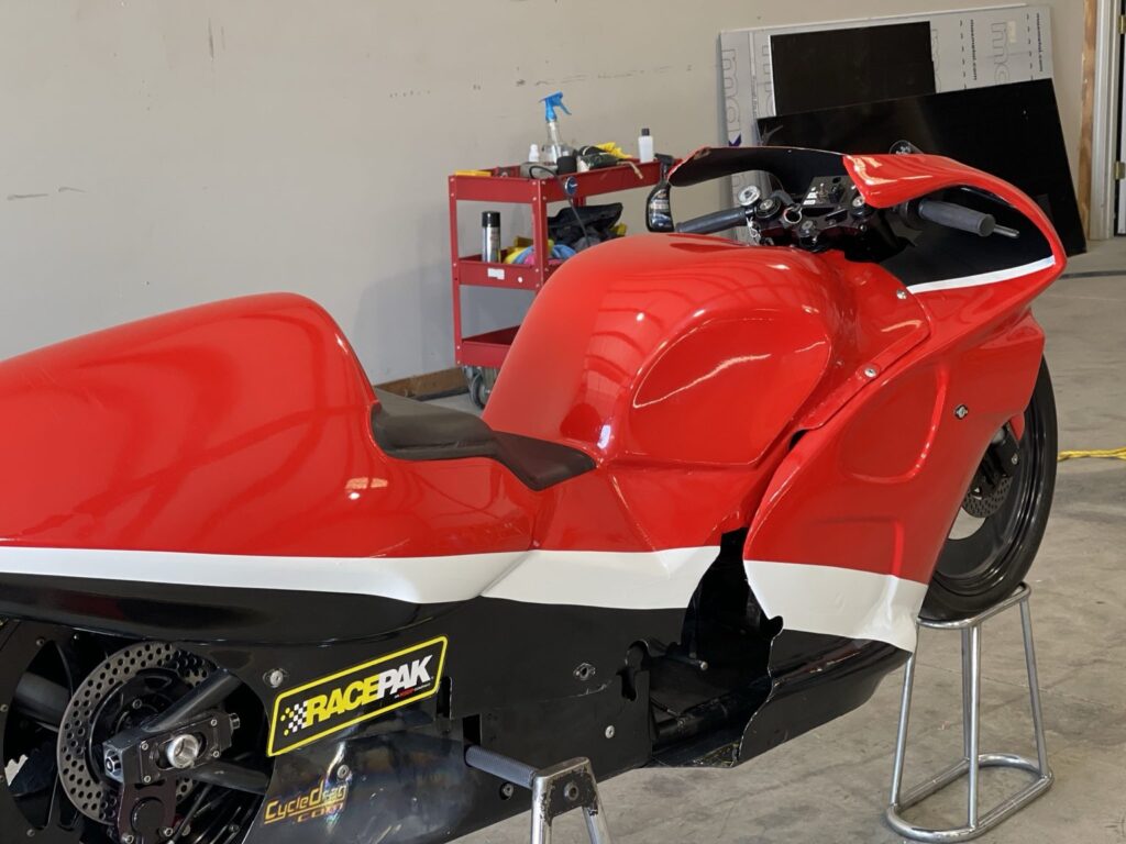 Rear-quarter view of the red White Alligator Racing drag bike showing bodywork and graphics
