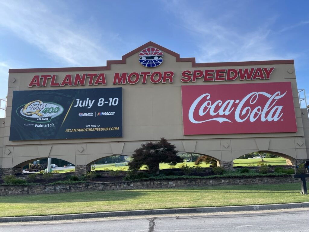 Atlanta Motor Speedway entrance monument with Quaker State 400 race-weekend promotion and Coca-Cola signage in July 2022