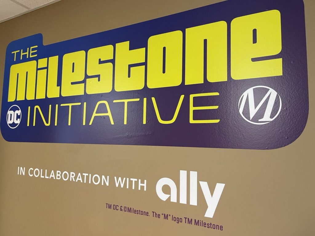 Purple and yellow DC Milestone Initiative panel with Ally collaboration lettering installed on a hospitality wall