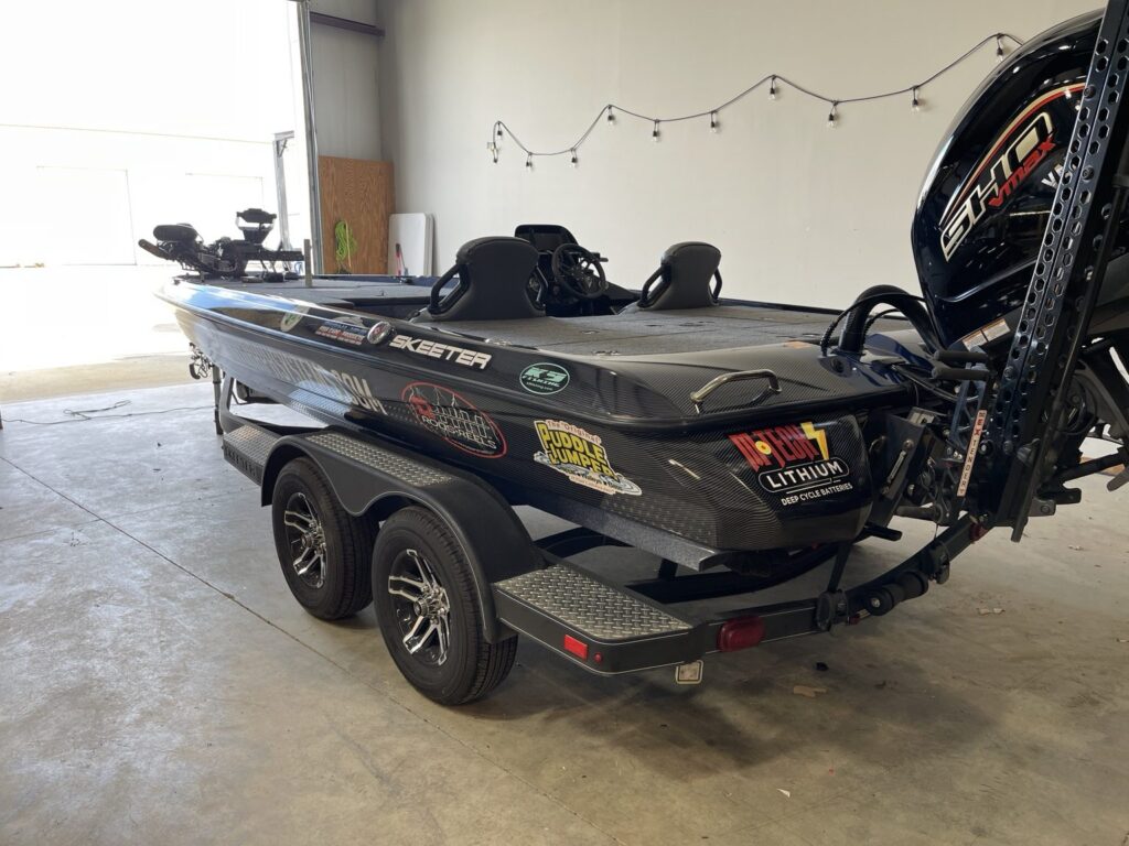 Rear three-quarter view of the wrapped Skeeter on its trailer