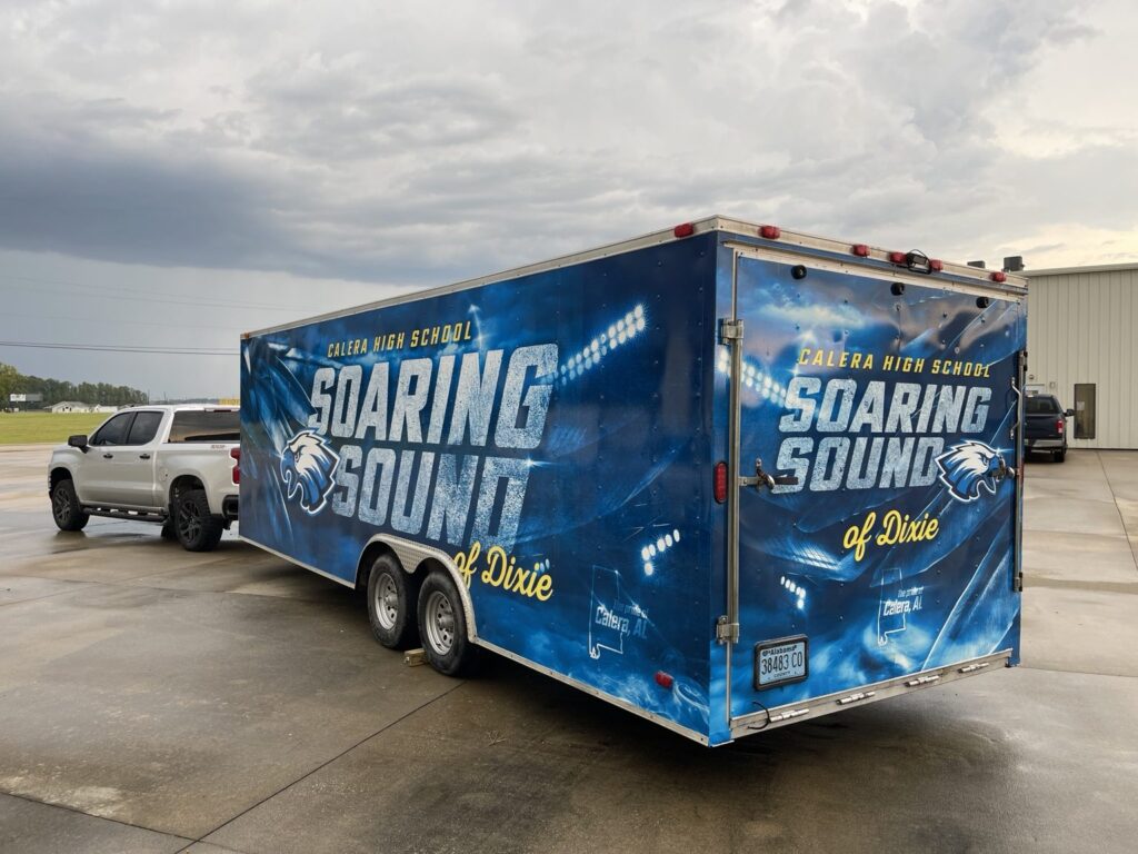 Rear and side view of the blue Calera High School cargo trailer with matching Soaring Sound of Dixie graphics and eagle branding across the trailer body.