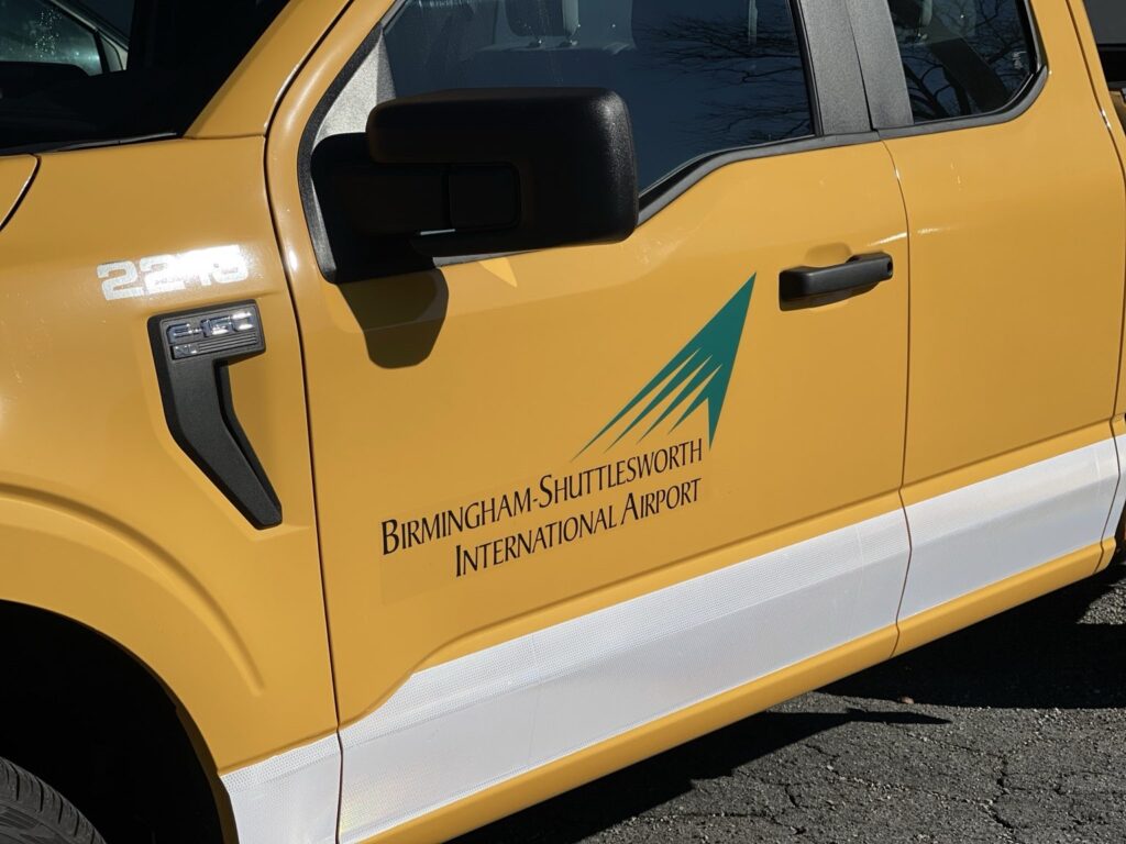 Close-up of the Birmingham-Shuttlesworth International Airport logo on a yellow truck door