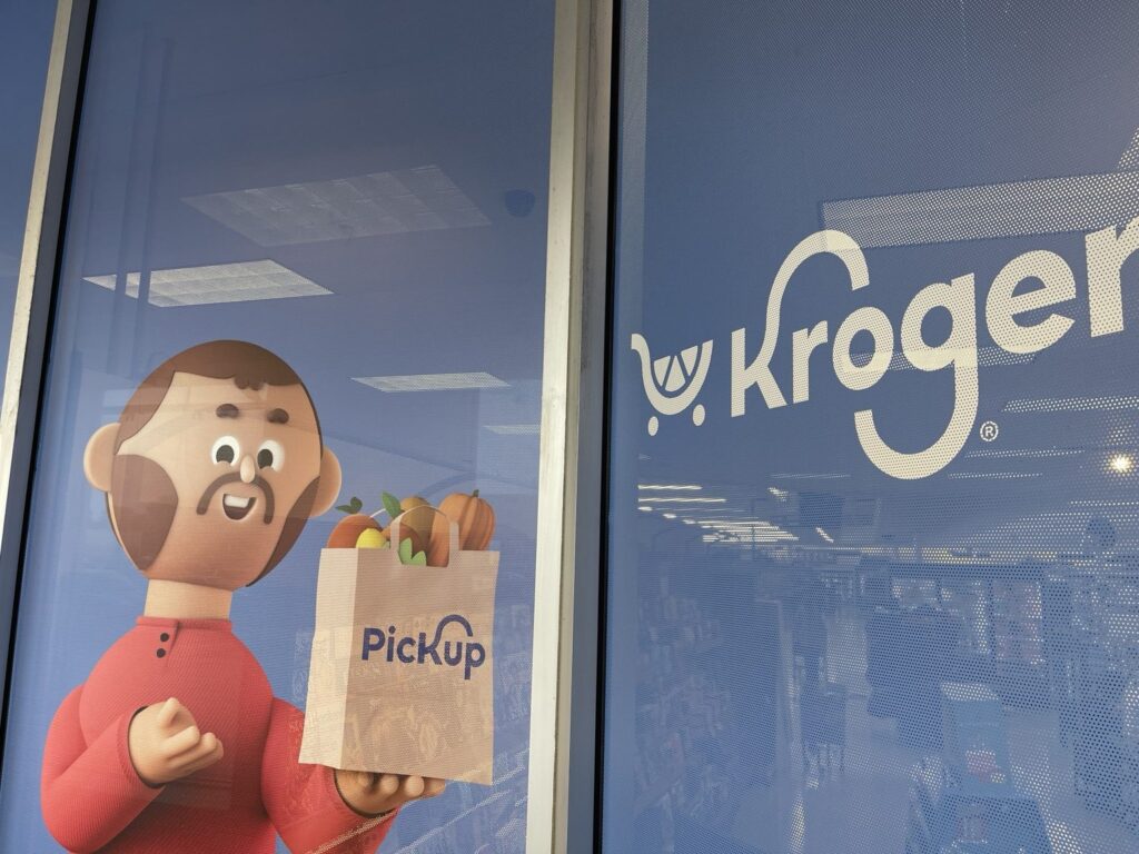 Close-up of the Kroger logo and pickup character on blue perforated window film