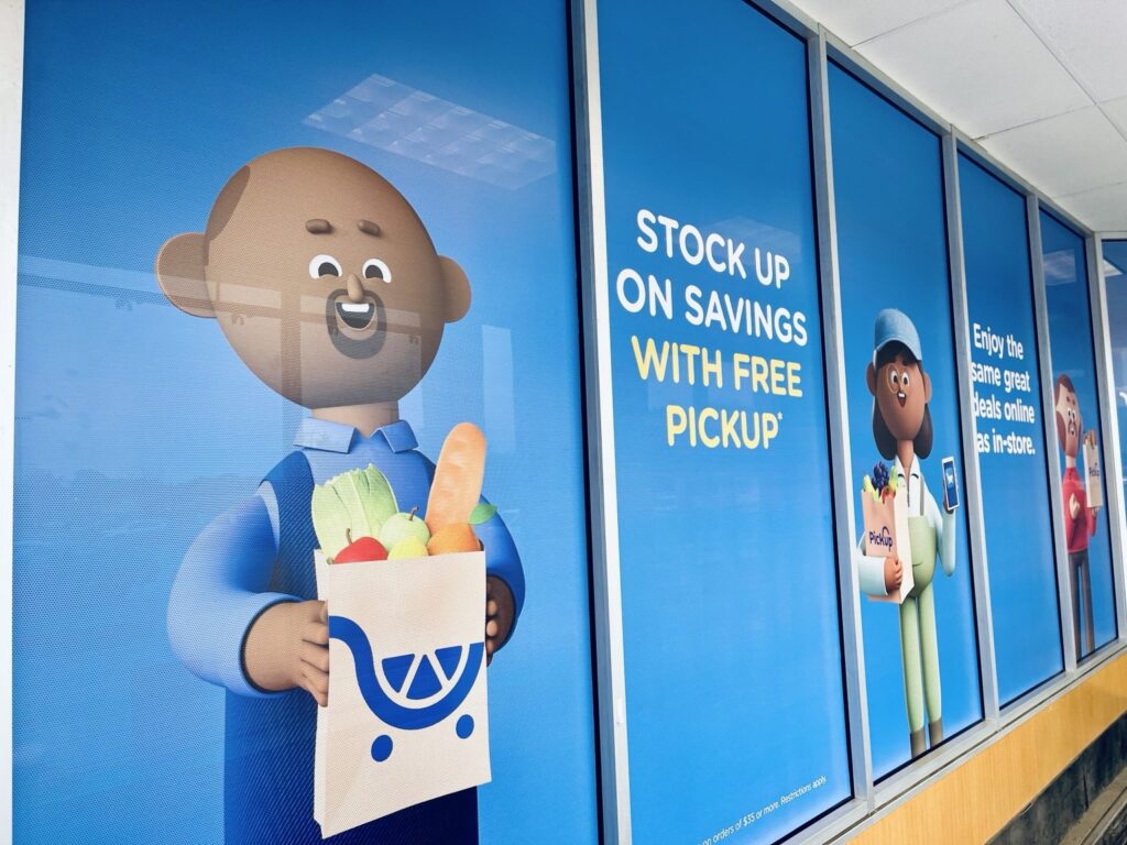 Kroger window graphics: multi-panel PickUp artwork with a blue background, illustrated shopper and free pickup offer
