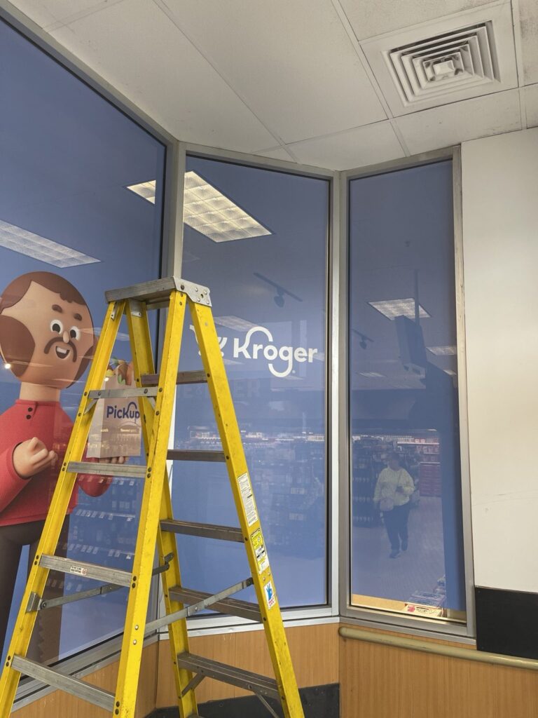 Interior view of Kroger PickUp perforated window film and a yellow installation ladder