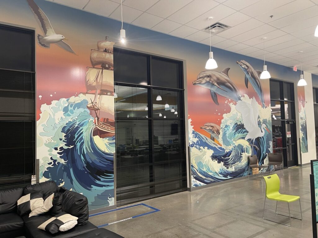 Coastal-themed wall mural with dolphins and ocean waves spanning windows