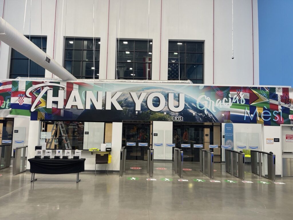 Thank You wall graphics over a facility entrance with international flags