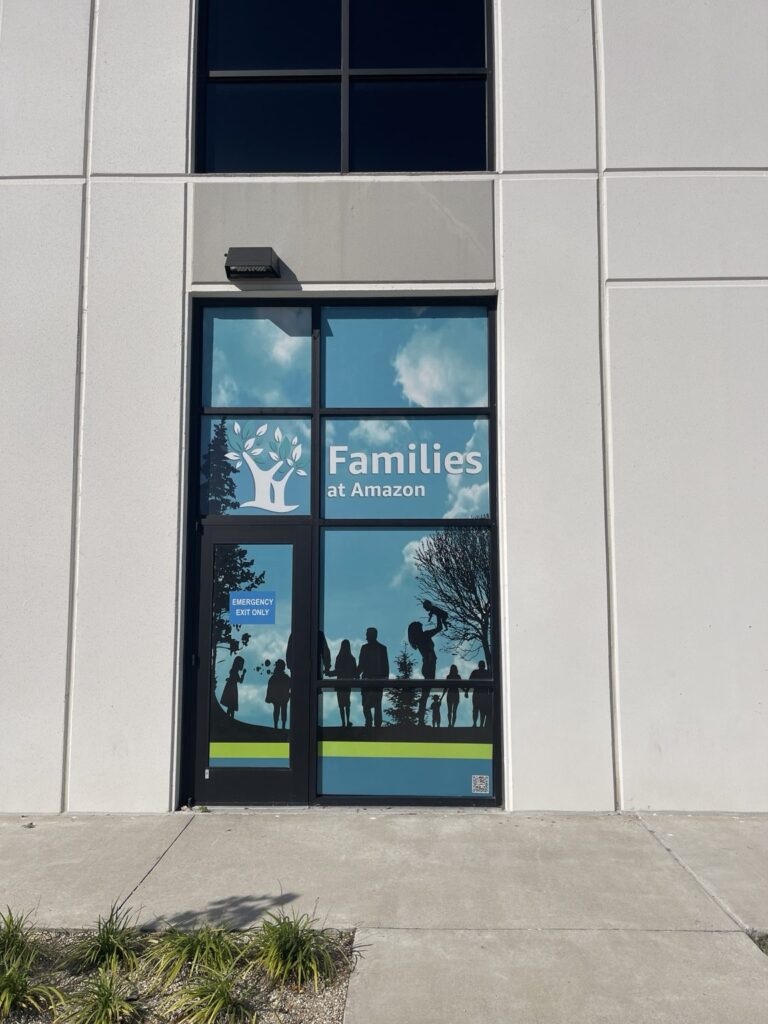 Families at Amazon graphics installed across a window and exit door
