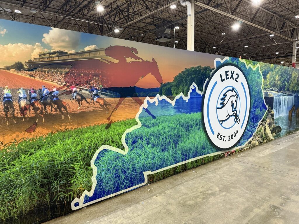 Warehouse wall wraps: wide interior warehouse wall mural showing horse racing, Kentucky outline, forest scenery and a large circular LEX2 horse emblem.