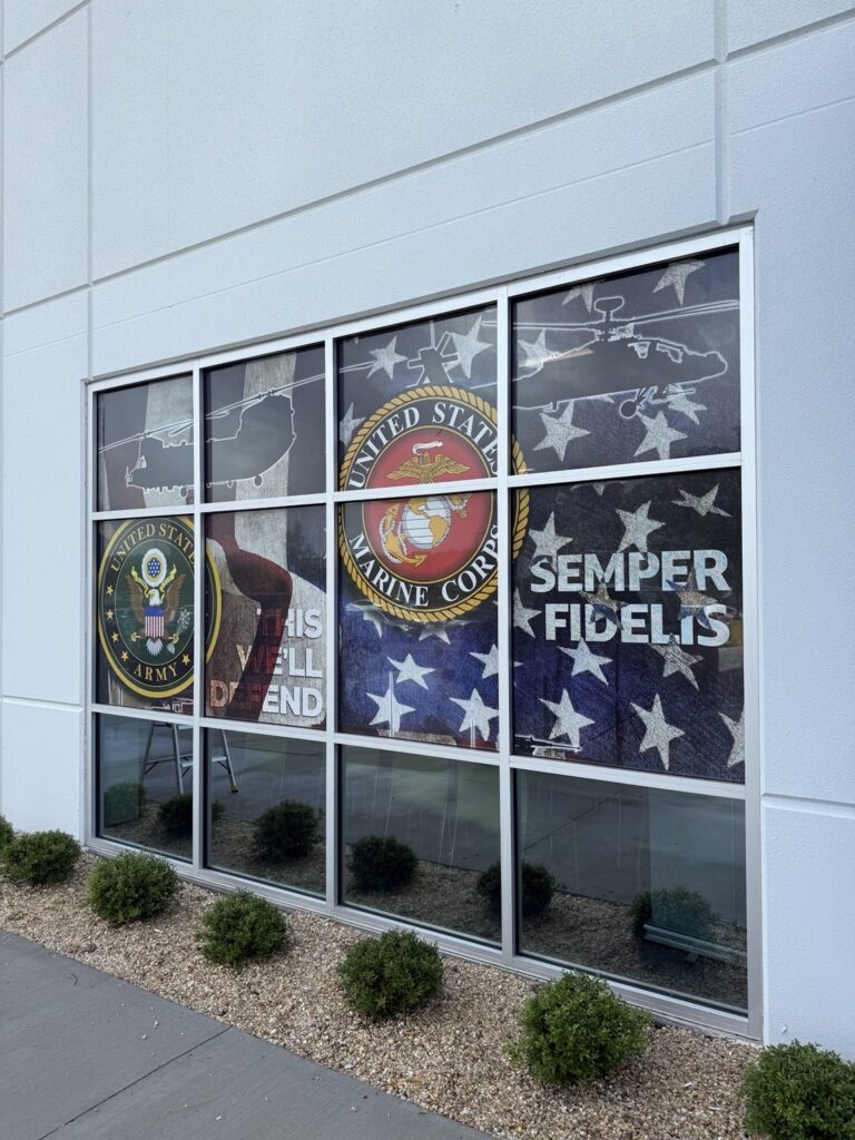 Window graphics featuring United States Army and Marine Corps emblems, helicopter silhouettes, flag imagery and SEMPER FIDELIS lettering.