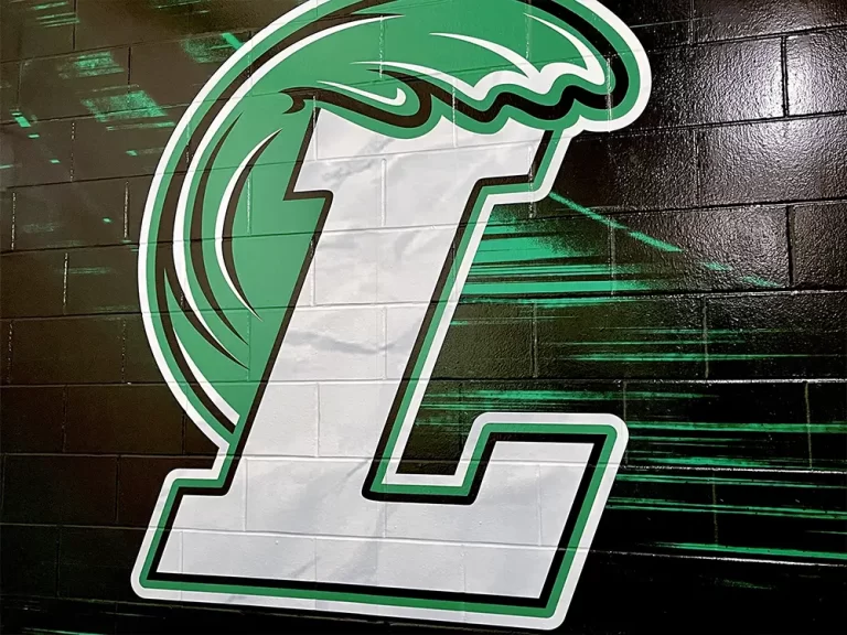 Green-and-white Legacy Credit Union logo graphic on a dark textured wall