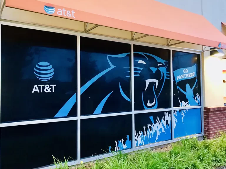 Window graphics installation on an AT&T storefront featuring Carolina Panthers artwork