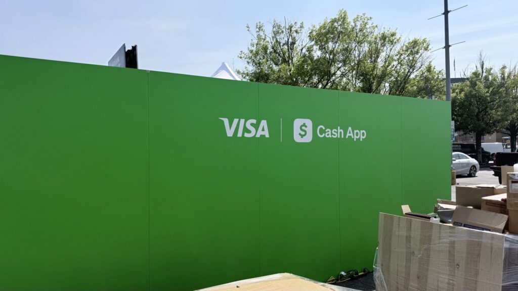 Large green Visa and Cash App sponsor graphics installed across outdoor wall panels
