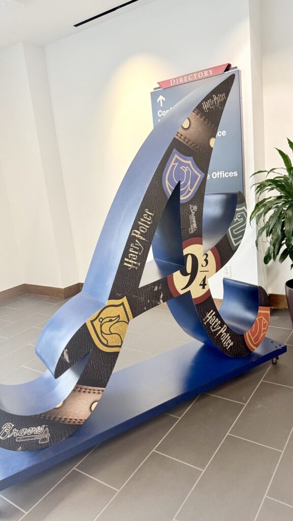 Angled close-up of the sculpted Braves logo wrapped in Harry Potter-themed artwork