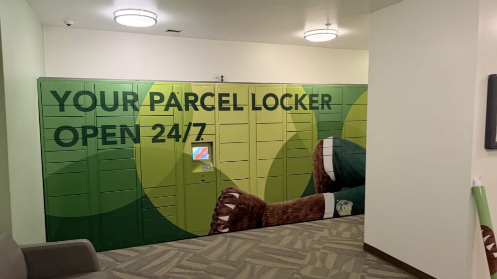 Parcel locker wrap at Georgia Gwinnett College with YOUR PARCEL LOCKER OPEN 24/7 graphics and the touchscreen and keypad left accessible.