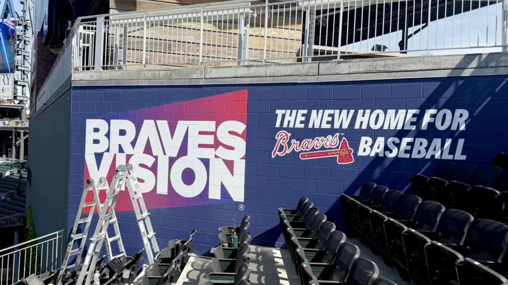 Braves Vision wall wrap on textured concrete block at Truist Park during installation by Black Diamond Designs