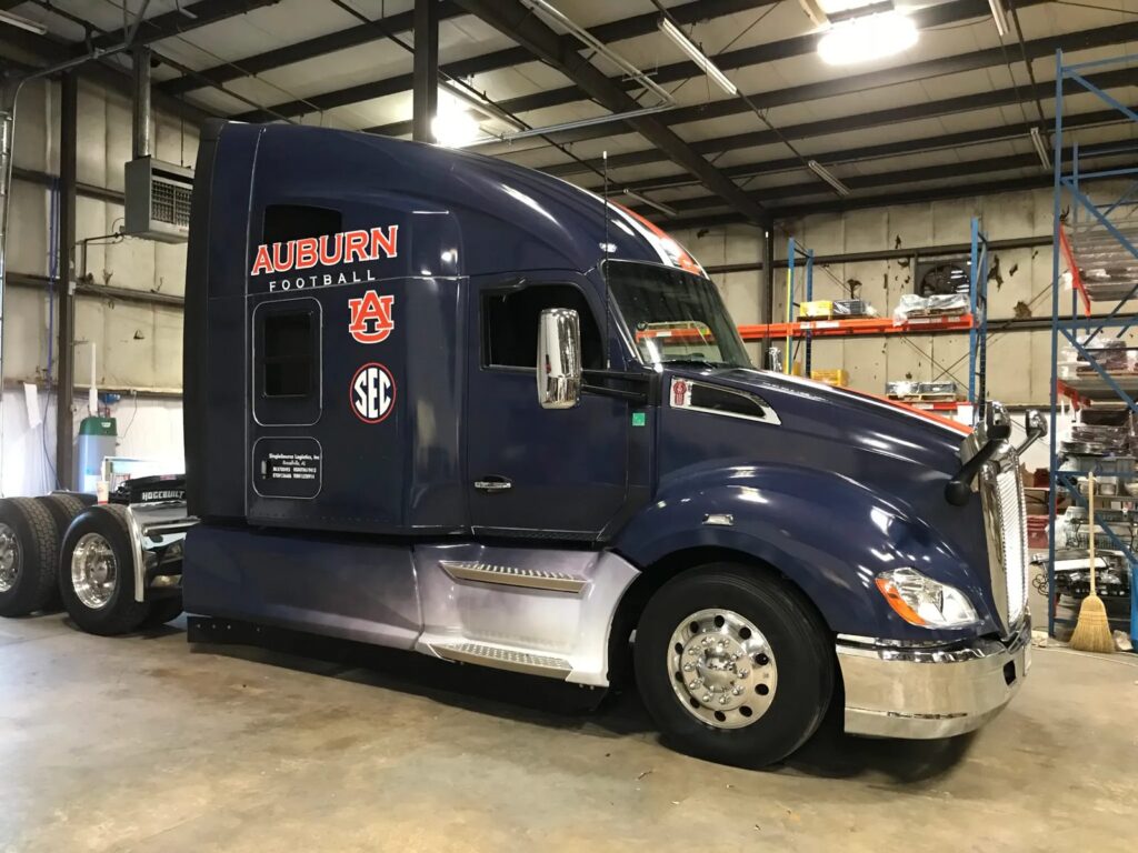 Auburn semi-truck graphics: navy Auburn Football tractor cab with AU and SEC logos installed by Black Diamond Designs